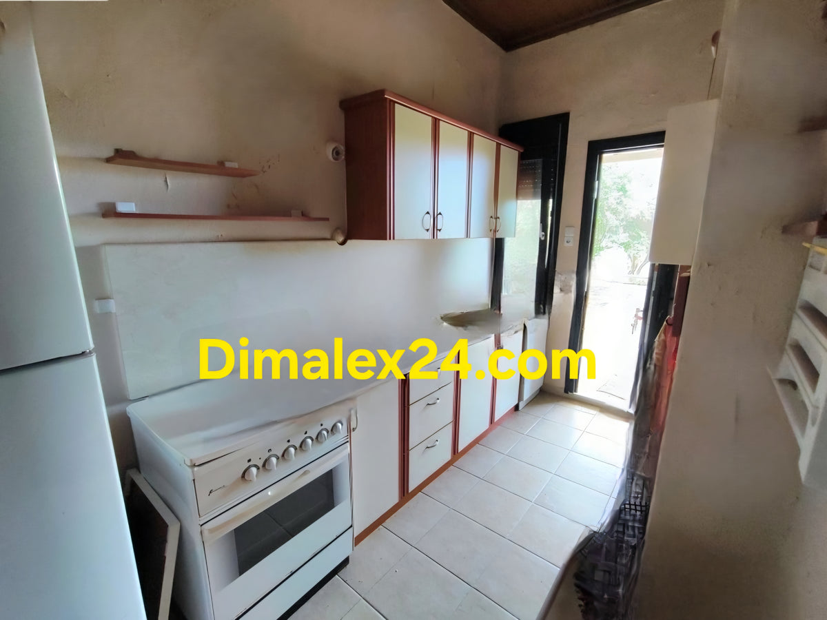 Оборудвана кухня с кухненски шкафове в обзаведена къща в Ароги.