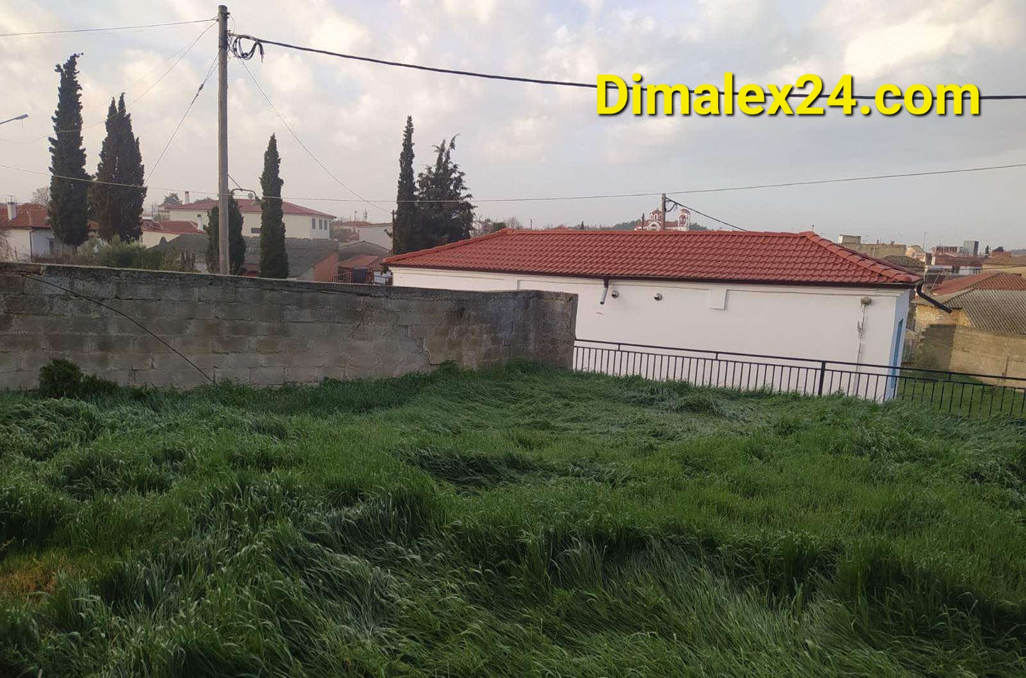 Парцел с висока трева и къща в село Ксилагани, област Родопи, Гърция. Подходящ за недвижими имоти в Гърция.