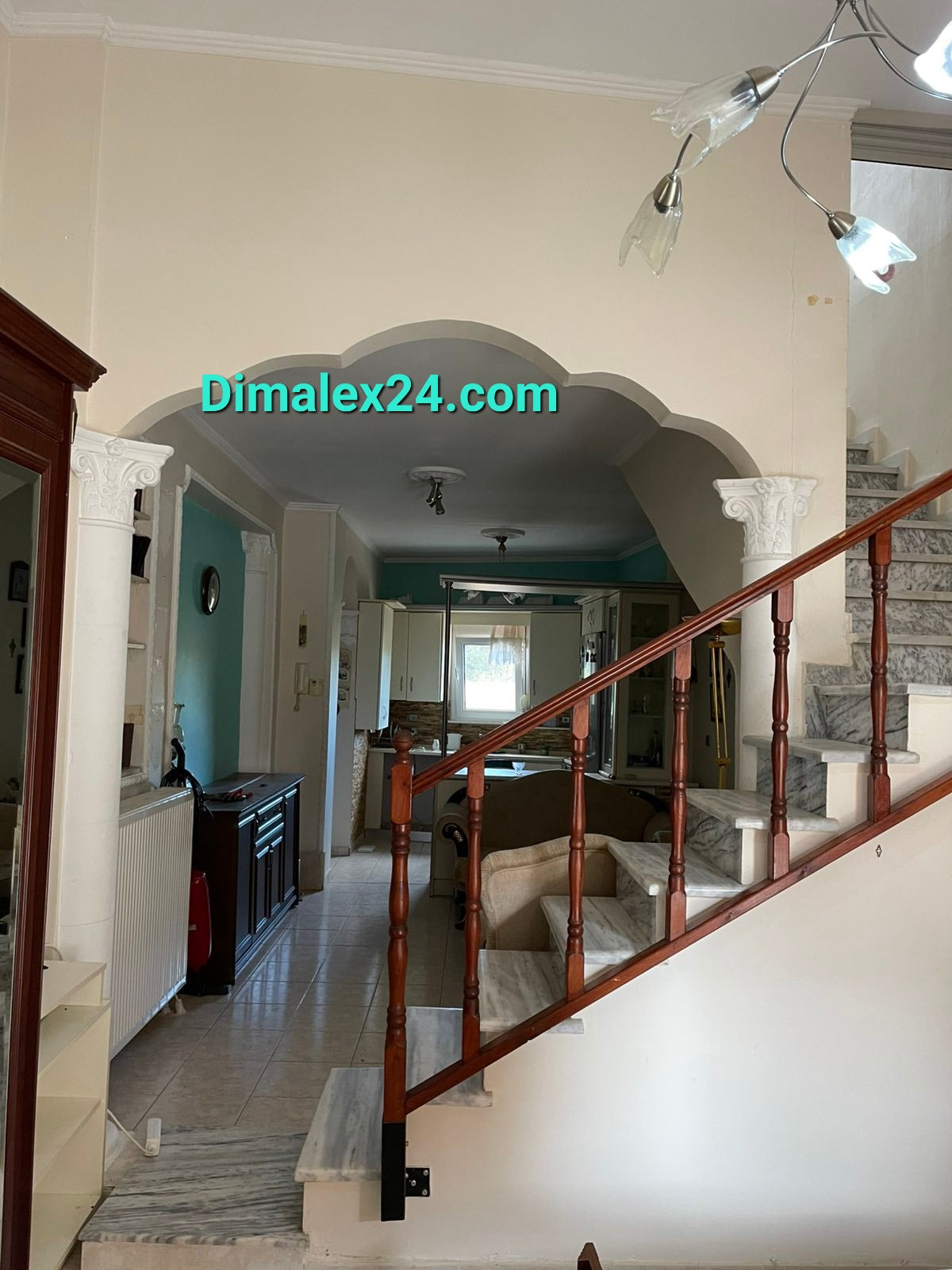 Interior view of a cozy mezonette in Ksilagani, Greece, showing stairway and living area furnishings.