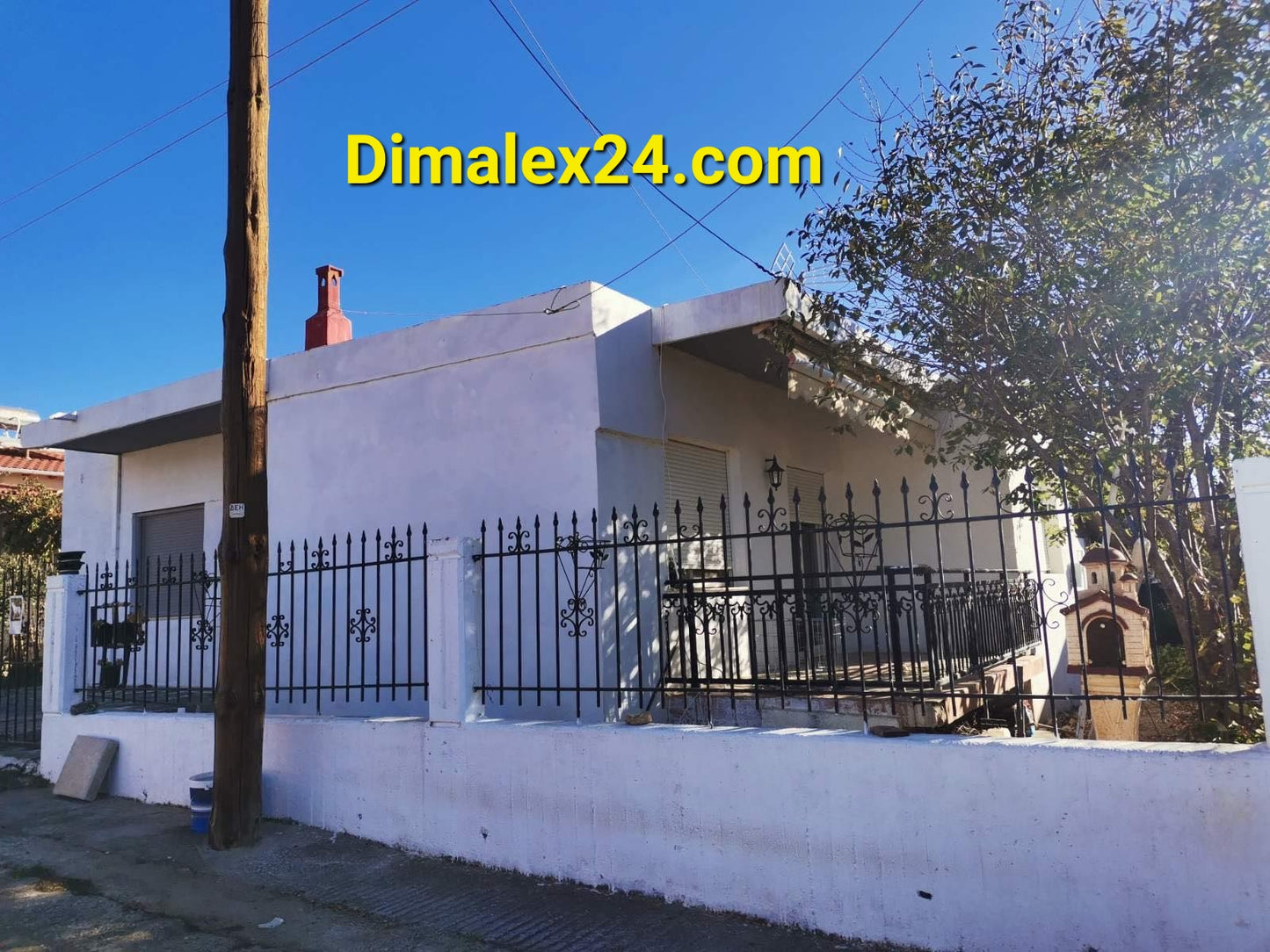 Exterior view of a house in Makri, Evros, Greece, with a fence and clear blue sky.