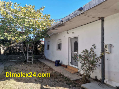 Exterior view of a house in Makri, Greece, featuring a garden, porch, and tree, ideal for low-cost properties.