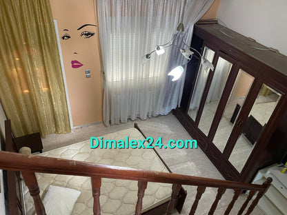 Interior view of a stylish bedroom featuring a bed, wardrobe, and decorative curtains.