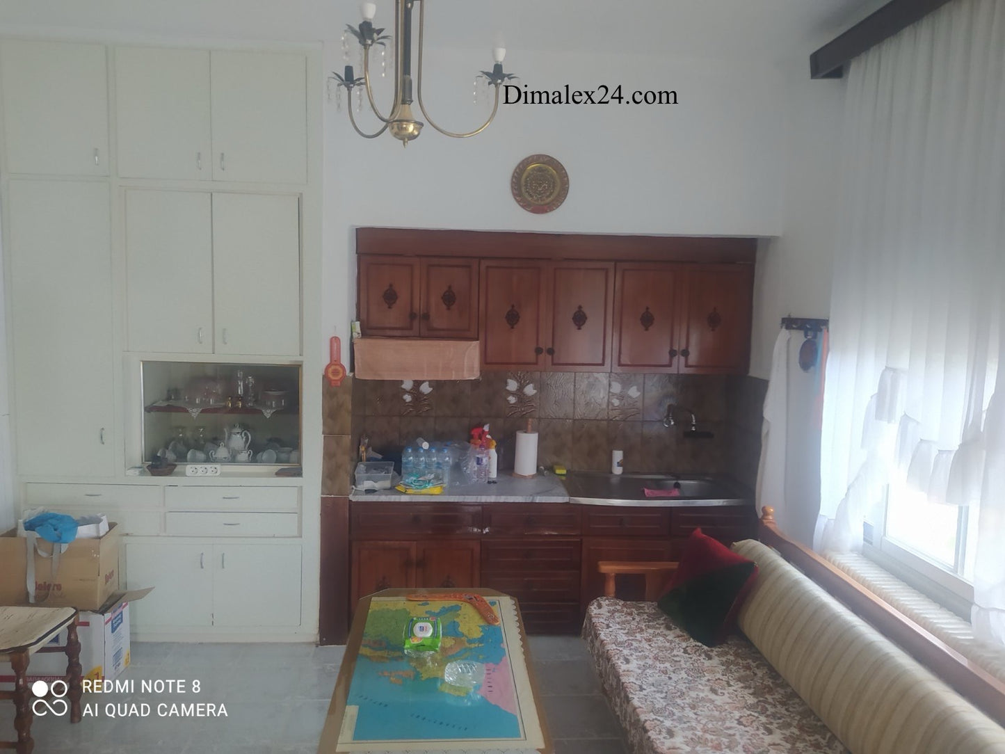 Interior view of a cozy kitchen with wooden cabinets in a house for sale in Ksilagani, Greece.