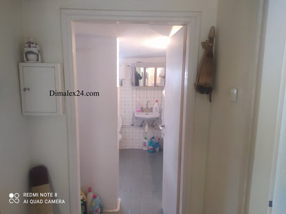 View of hallway leading to a bathroom in a house in Greece, showcasing clean and organized space.