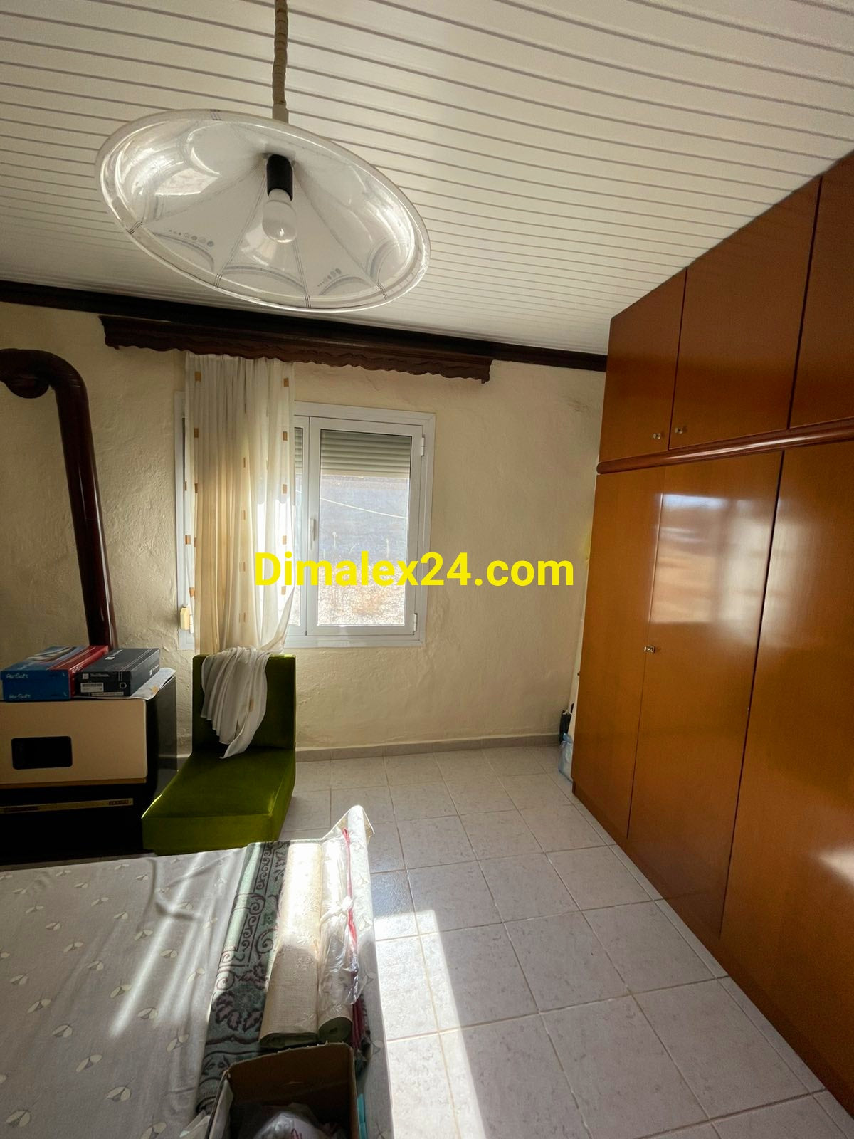 Част от спално помещение с гардероб,голяма спалня и прозорец с алуминиева дограма и ролетни щори в Гърция.