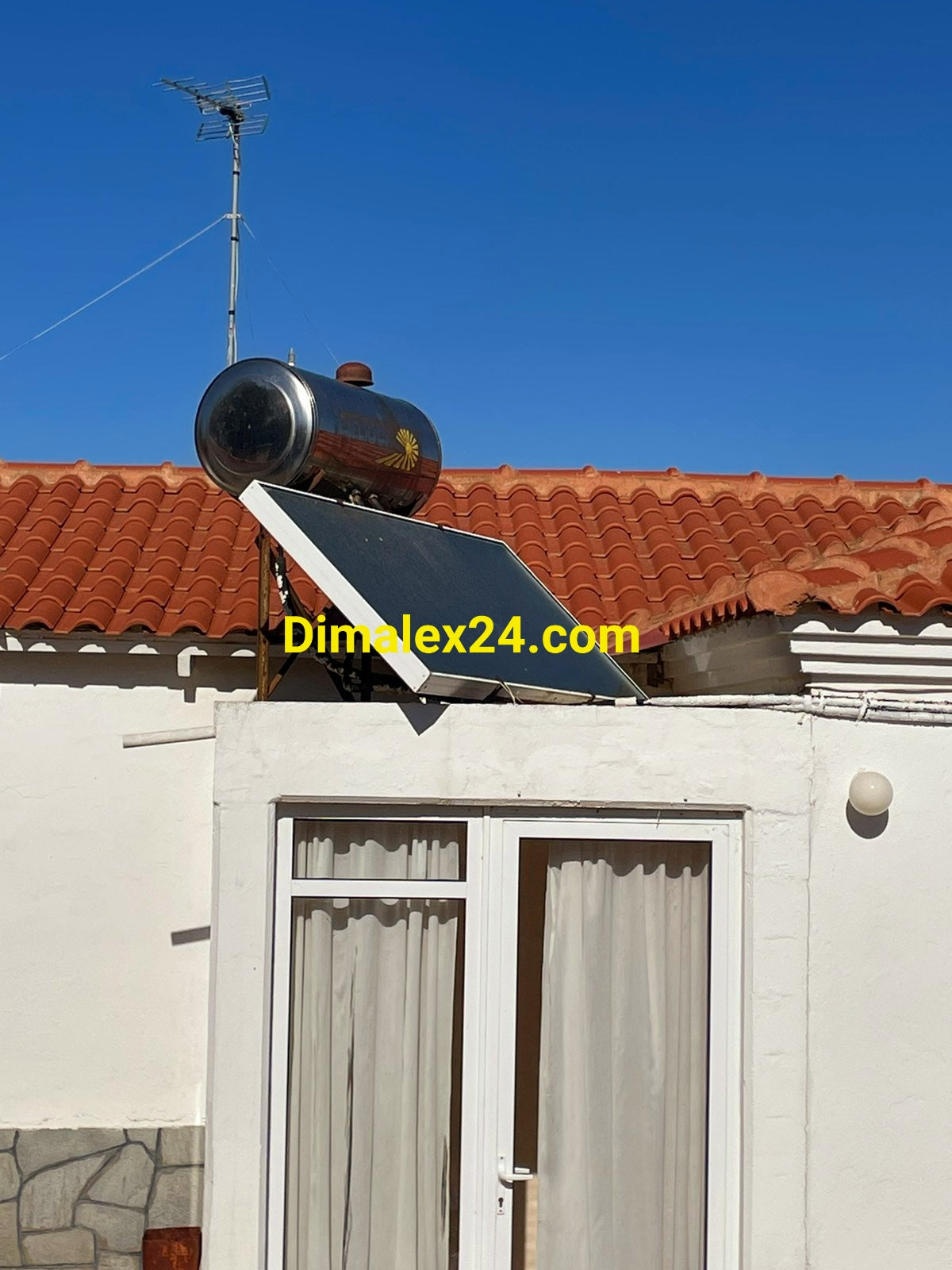 Соларен бойлер със соларен панел на покрива на къща в Северна Гърция, Проскинитес.