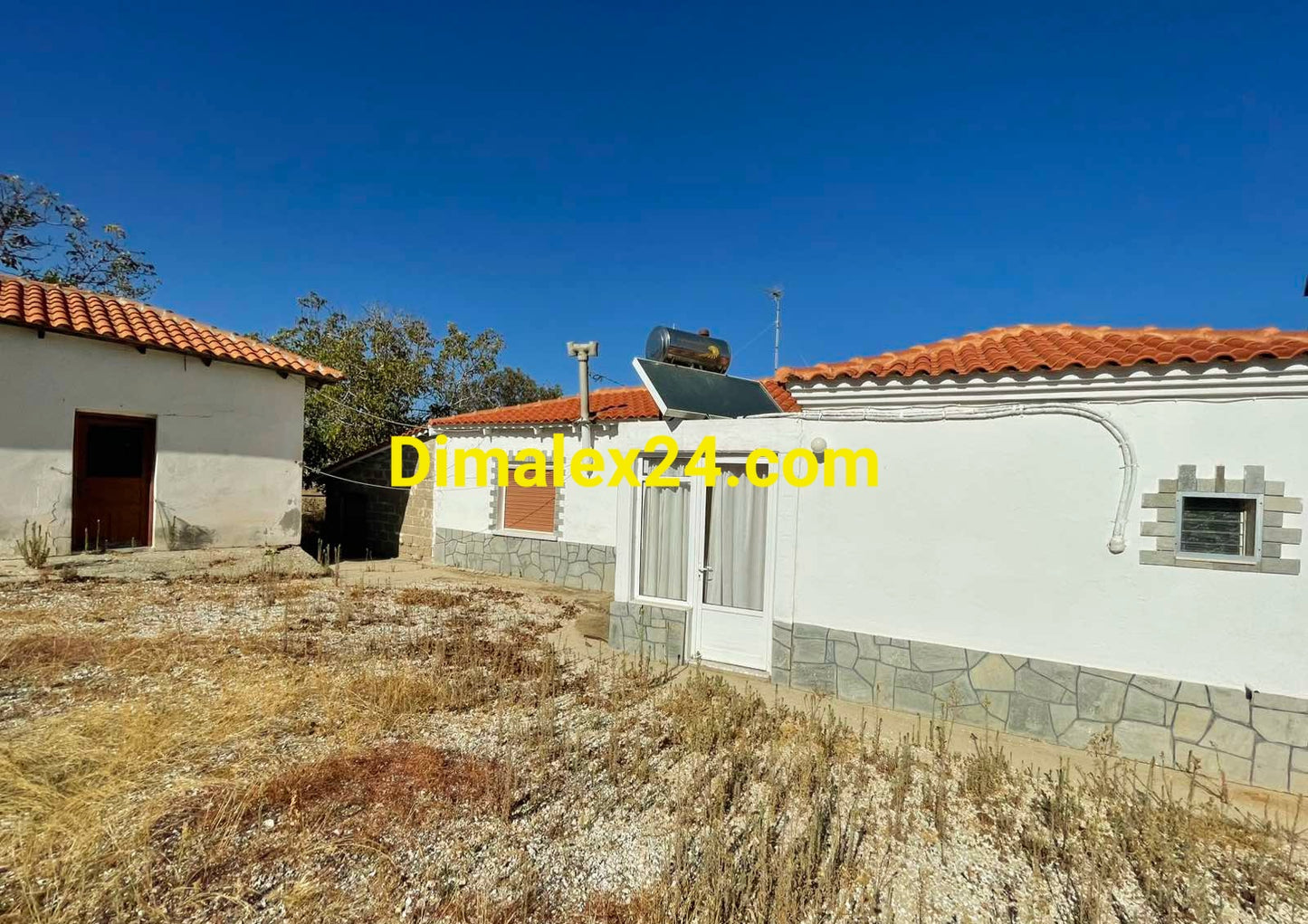 Част от двор с къща на един етаж в Северна Гърция.