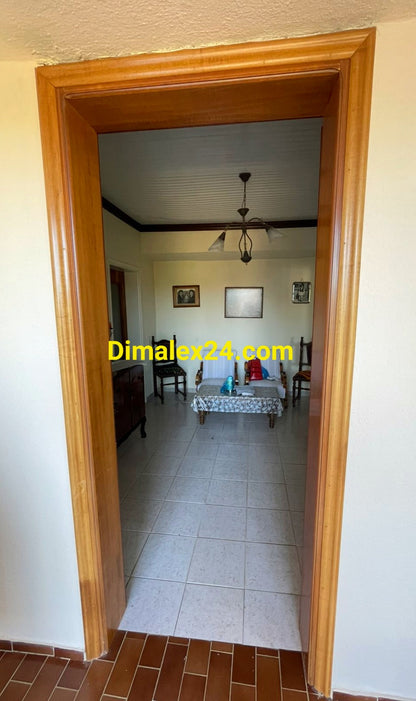 Изглед от коридора към просторен хол с обзавеждане в Гърция.