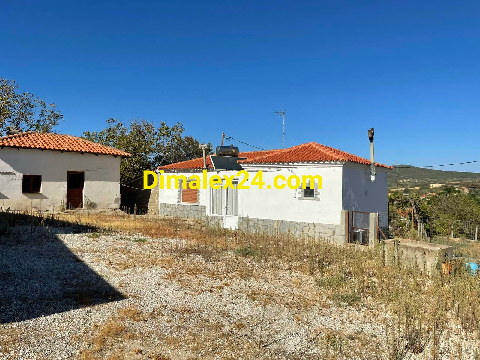 Къща в Проскинитес, Северна Гърция - фасада с нова гограма и соларен бойлер на покрива.