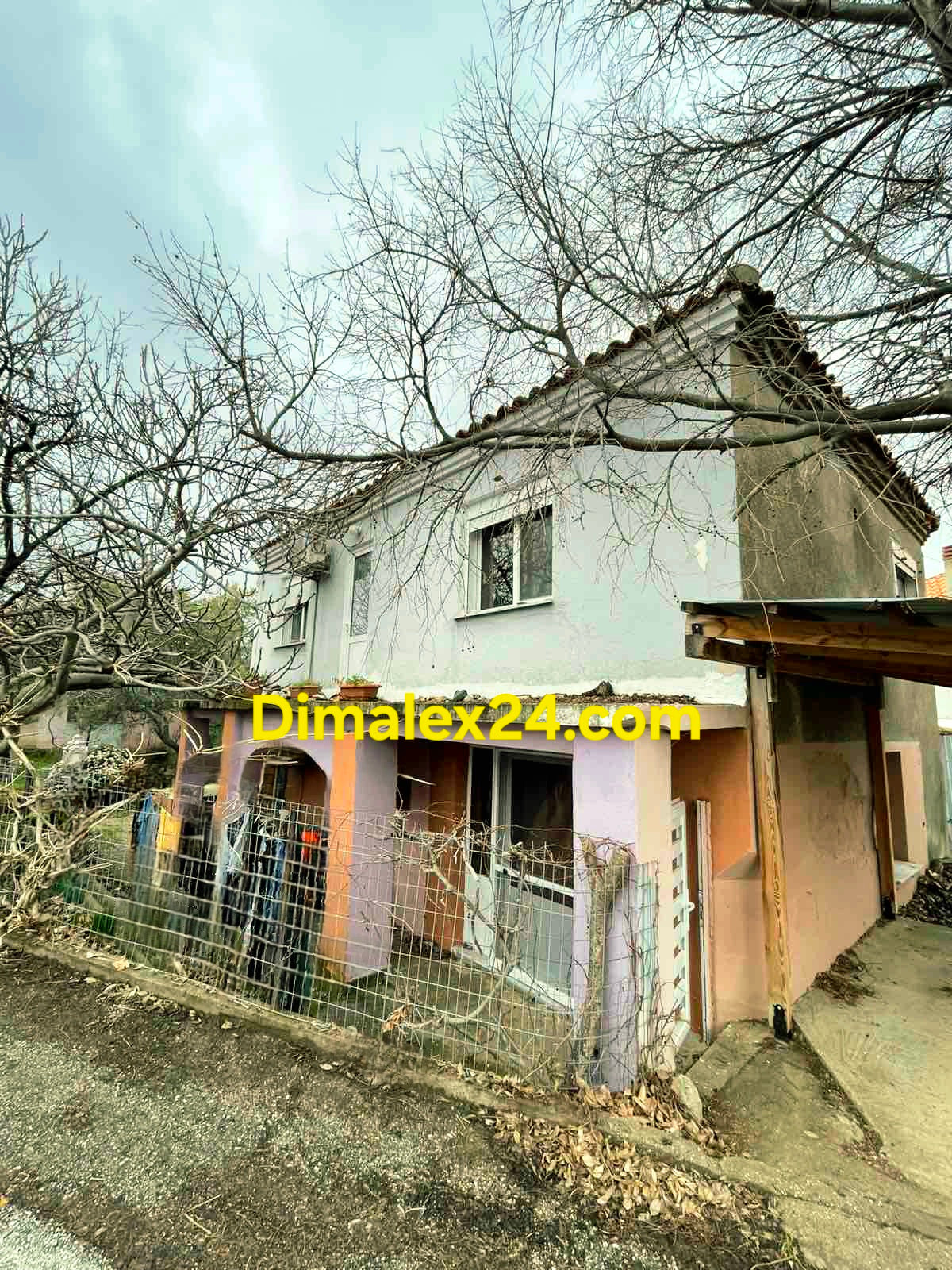 Фасада не къща в Проскинитес, Гърция с лице на асфалтова улица.