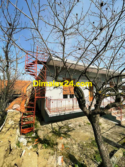 Фасада на къща с вита стълба към покрива който може да бъде и достроен като втори етаж в тих район Северна Гърция.