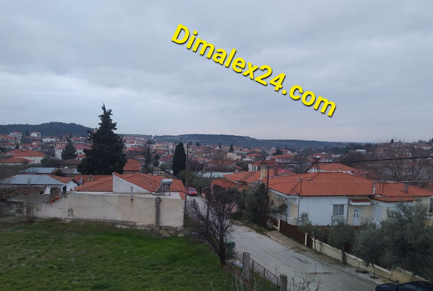 View of residential area in northern Greece with rooftops and greenery, showcasing affordable properties.