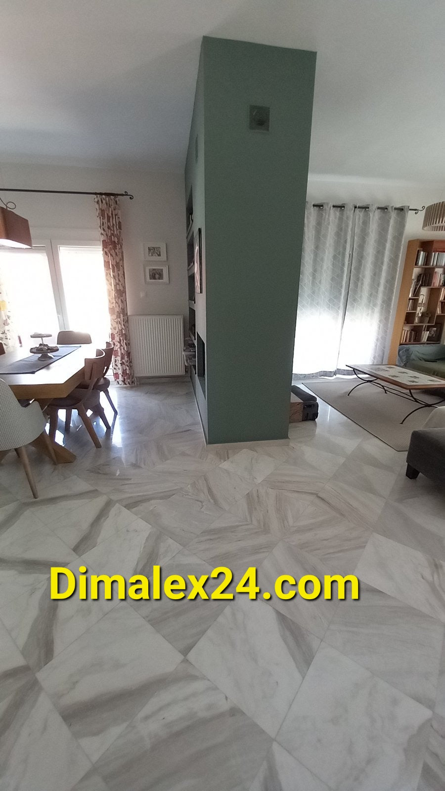 Interior view of a home in Greece showcasing a spacious dining area, modern decor, and elegant marble flooring.