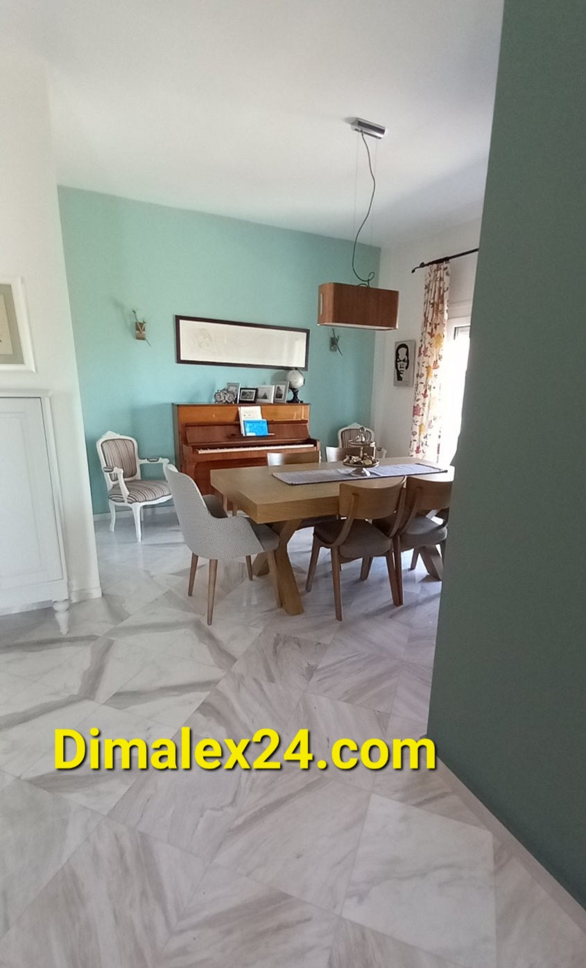 Stylish dining area featuring a wooden table, chairs, and a piano in a cozy home setting.