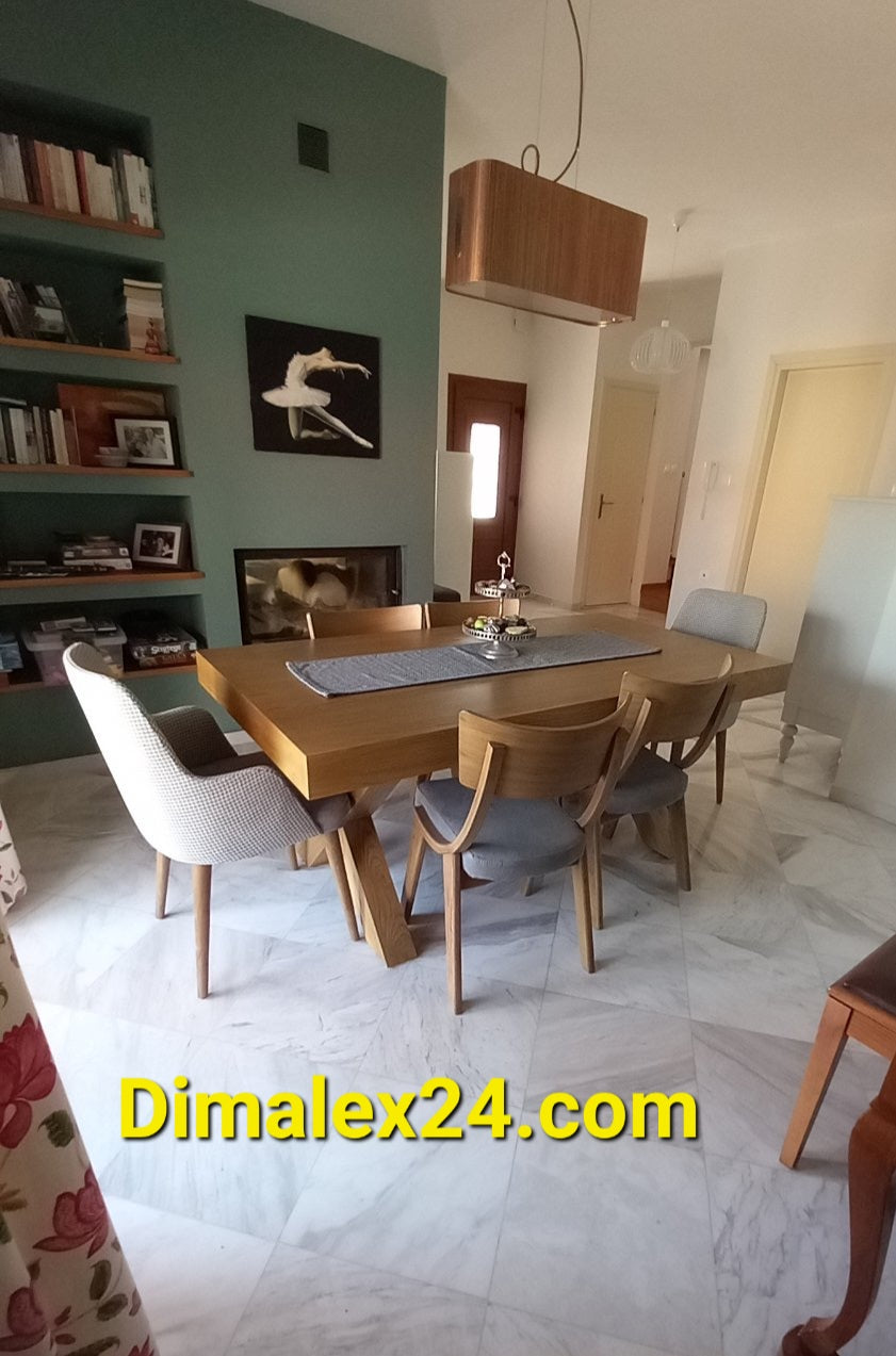 Modern dining room featuring a wooden table, stylish chairs, and a bookshelf, ideal for home decor inspiration.