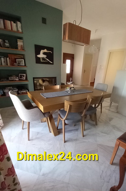 Modern dining room featuring a wooden table, stylish chairs, and a bookshelf, ideal for home decor inspiration.