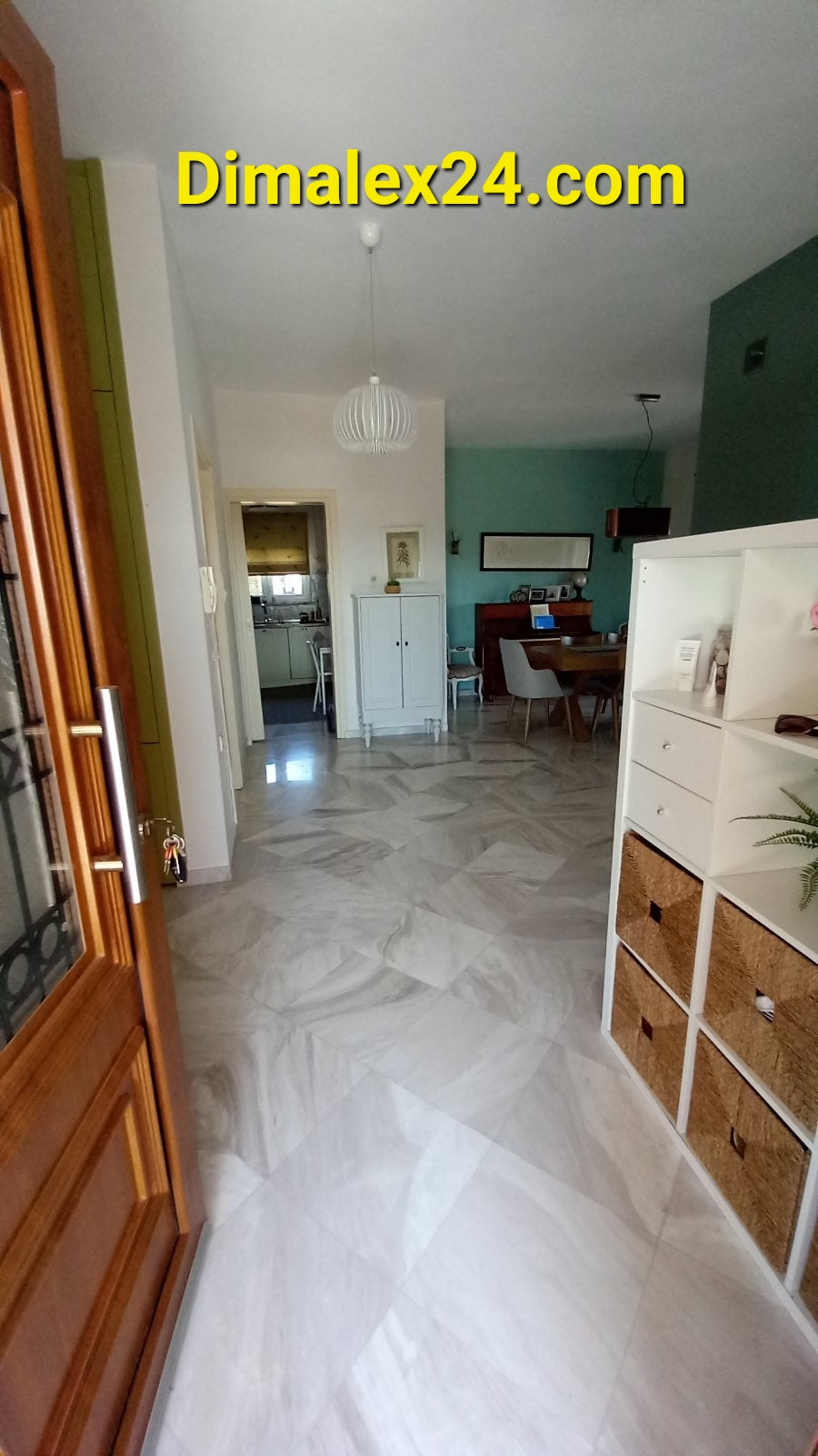 Spacious entrance hallway leading to a modern living area with dining table in a stylish home.