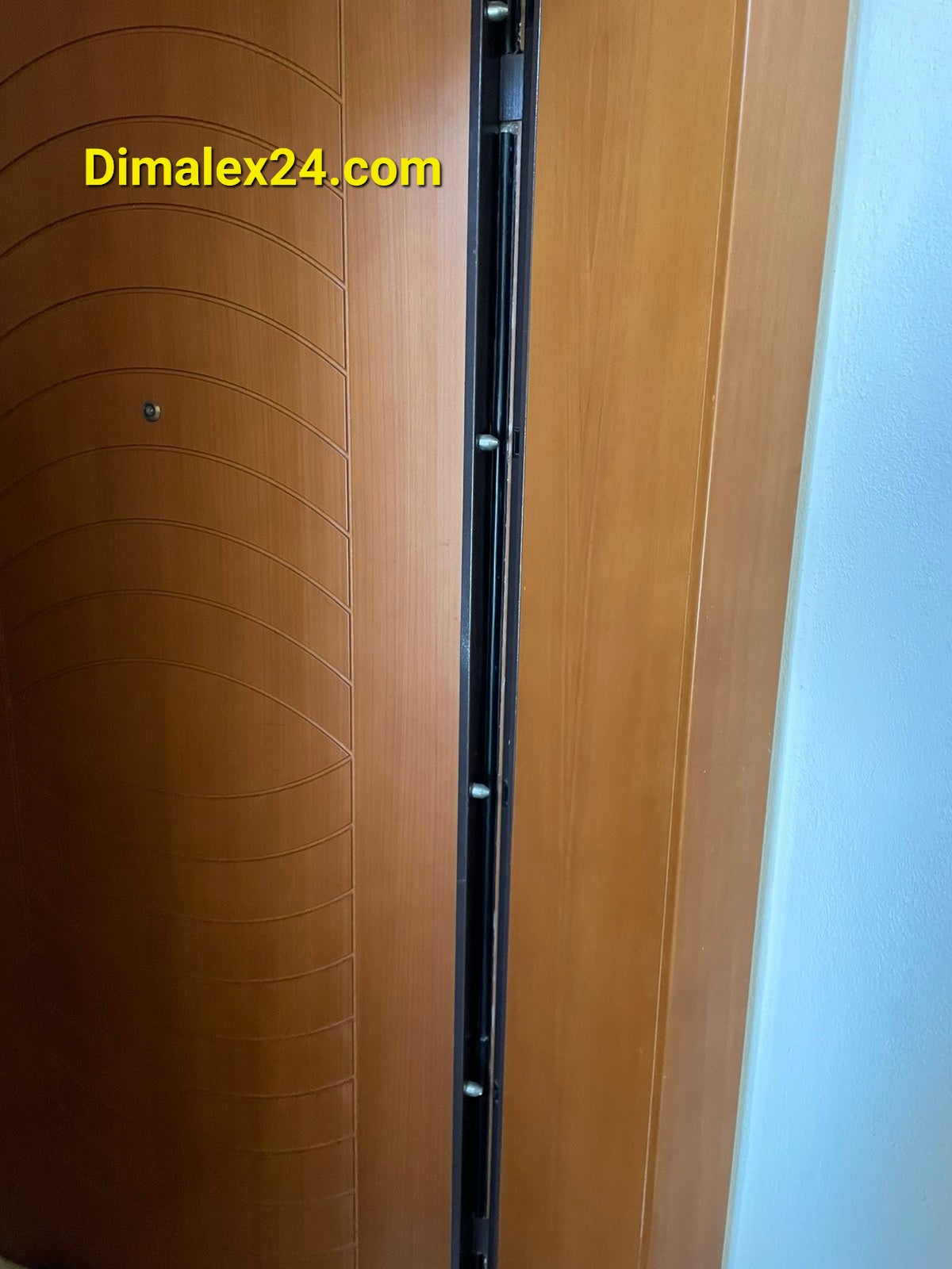 Detailed view of a modern apartment door lock mechanism in wood finish.