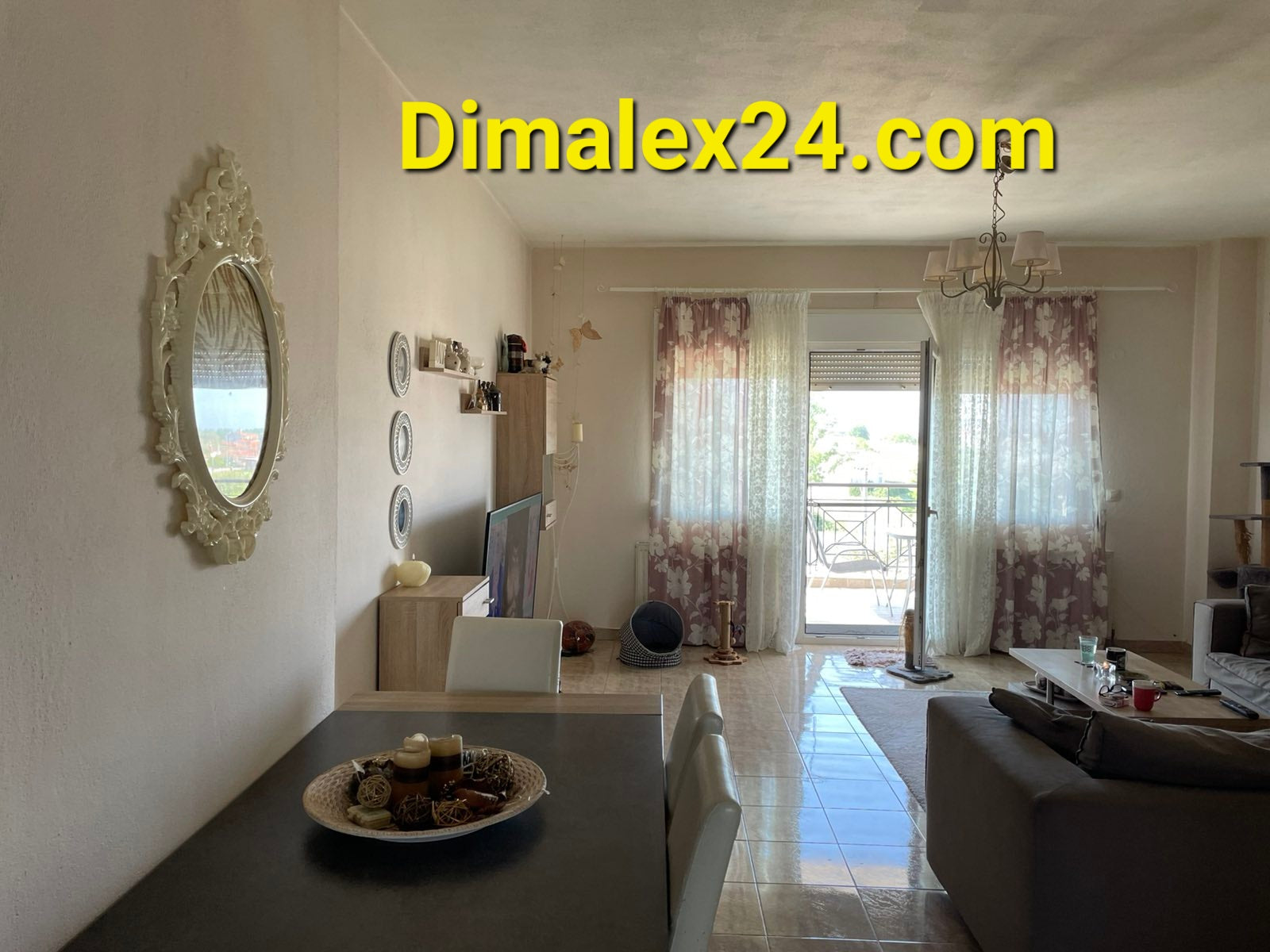 Modern living room in a Greek apartment featuring a dining area, stylish decor, and natural light from the balcony.