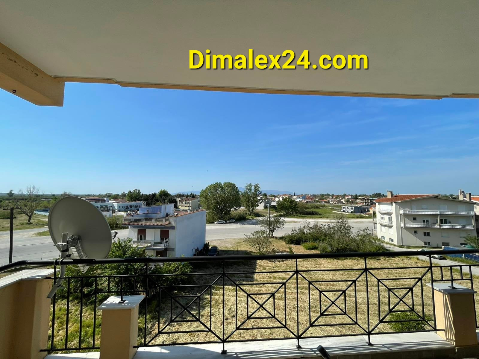 View from a balcony in Хрисуполи, Greece, showcasing the surrounding landscape and nearby buildings.