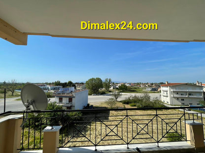 View from a balcony in Хрисуполи, Greece, showcasing the surrounding landscape and nearby buildings.
