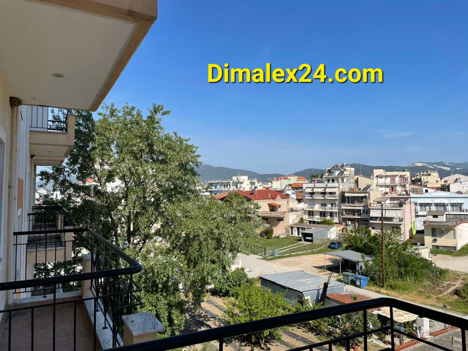 View from apartment balcony in Hrisoupoli, Greece, featuring cityscape and greenery.
