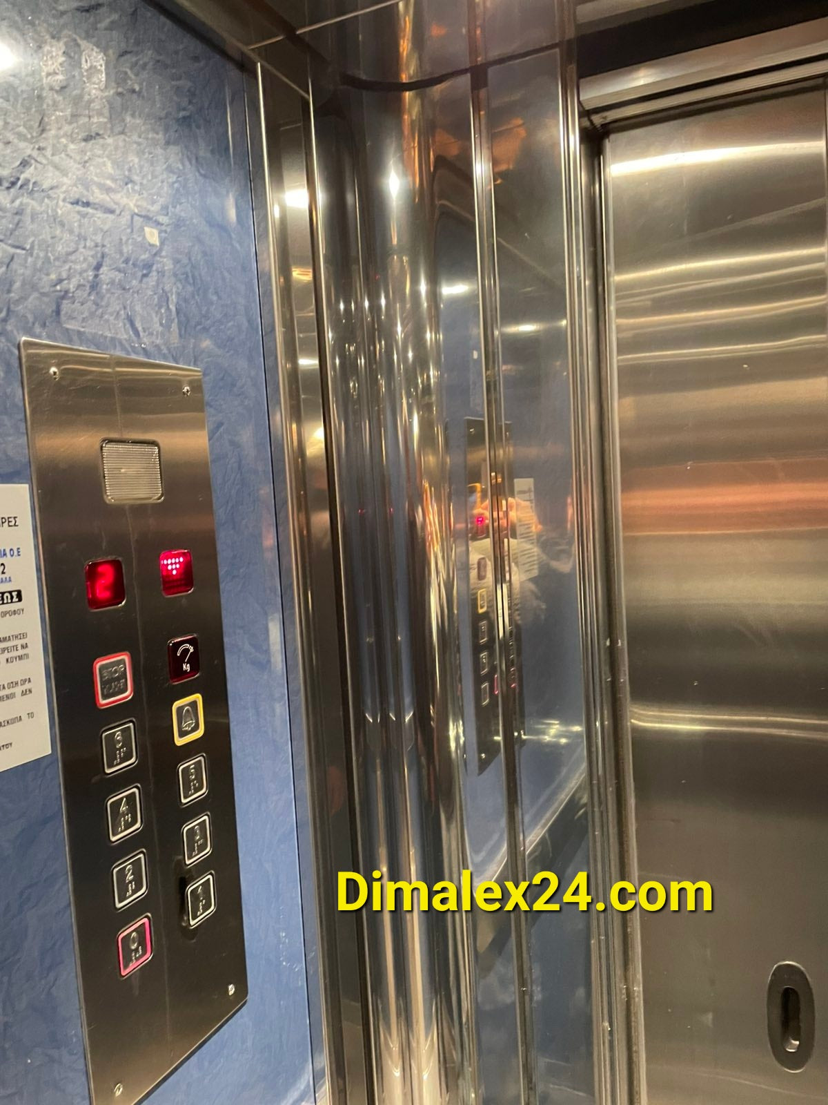 Interior view of an elevator with control panel and mirrored walls, showcasing modern design and functionality.